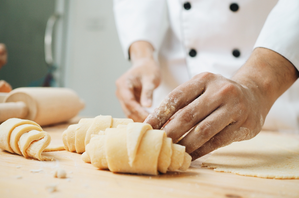 Pessoa fazendo croissant. Graduação em culinária.