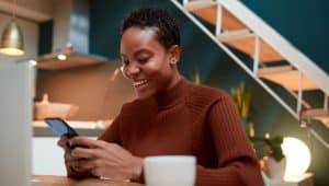 mulher com celular na mão acessando o app consultoria educação