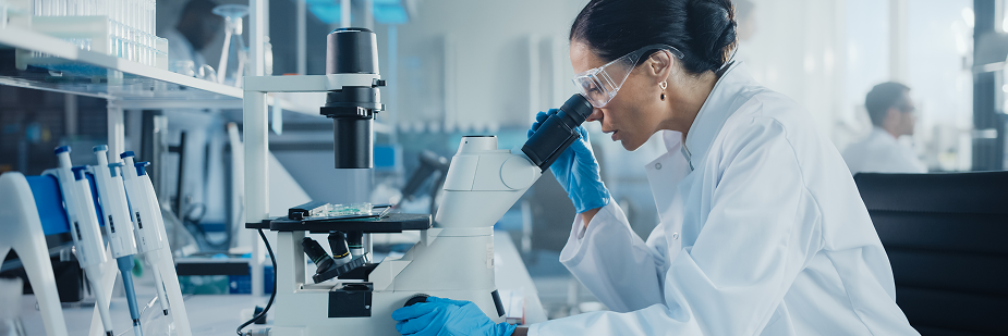 Biomédica usando microscópio. Biomedicina salário.