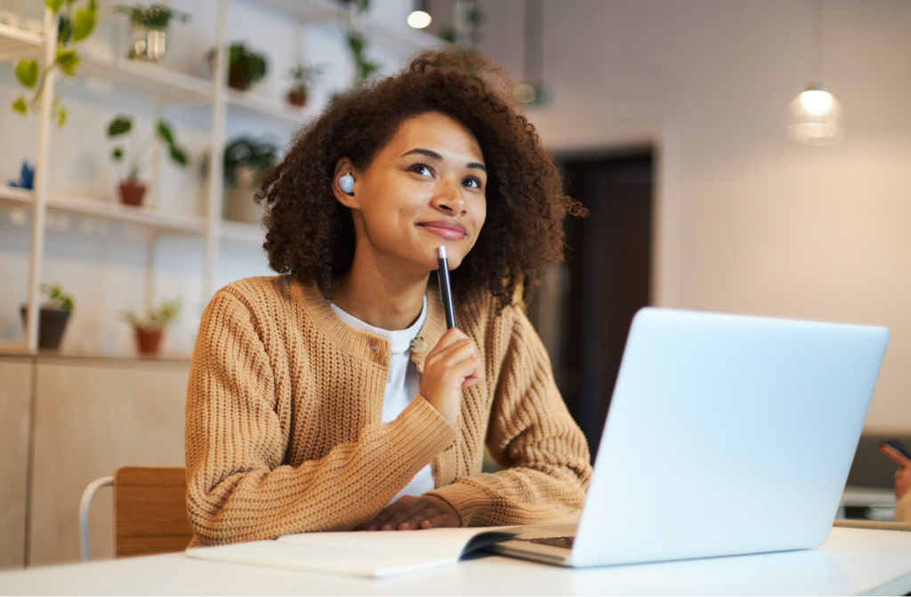 Mulher pensativa sentada em frente ao computador. Como se organizar financeiramente.