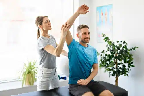 Fisioterapeuta exercitando paciente em seu braço
