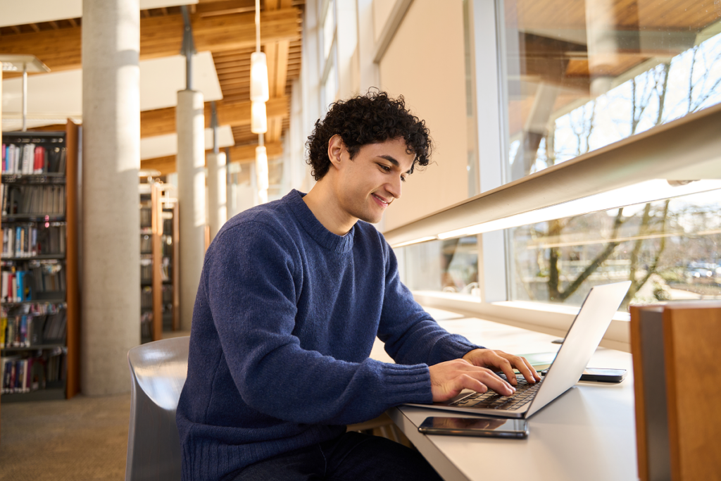 Homem se inscrevendo na faculdade em biblioteca. Faculdade de Engenharia EAD Anhanguera