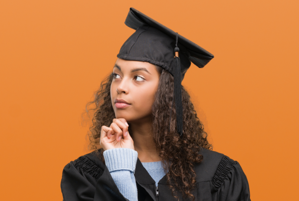 Mulher vestida com roupa de formanda pensativa. Curso técnico ead.