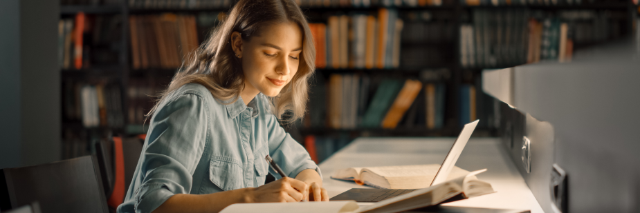 Mulher estudando no computador em uma biblioteca. Curso técnico ead.