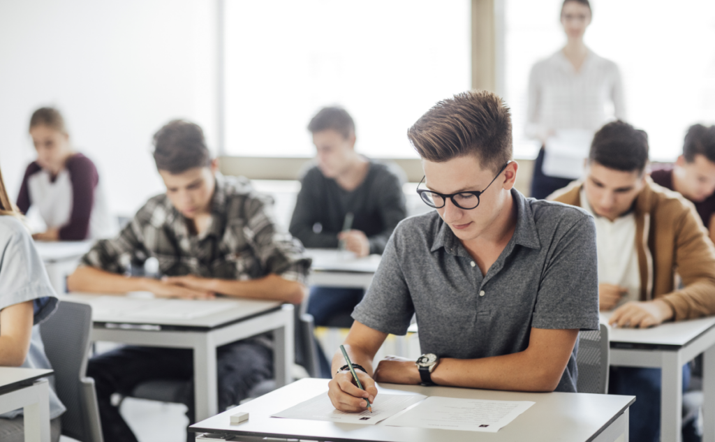 Imagem de jovens fazendo uma prova em uma sala de aula. prova do eja. 
