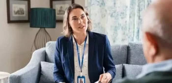 Mulher ouvindo idoso e anotando informações em caderno