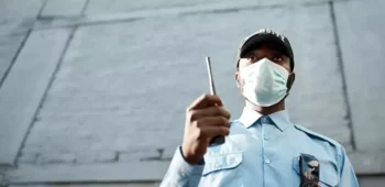 Segurança com comunicador do lado de fora de prédio