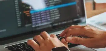 Homem digitando em laptop códigos