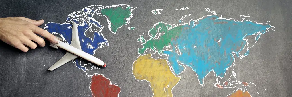 pessoa segurando avião em miniatura em cima de mapa mundial