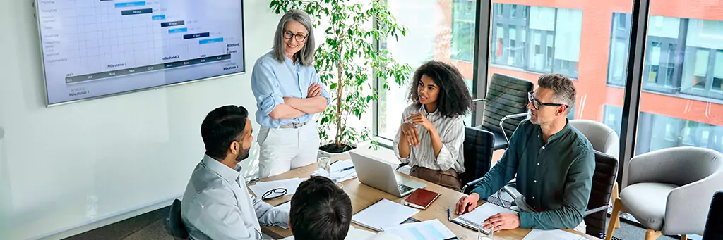 Pessoas reunidas em escritório apresentando dados