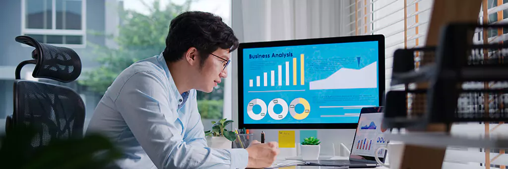 jovem trabalhando com dados com computador e laptop