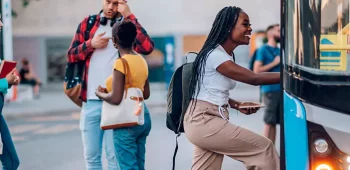 moça em faculdade subindo em ônibus