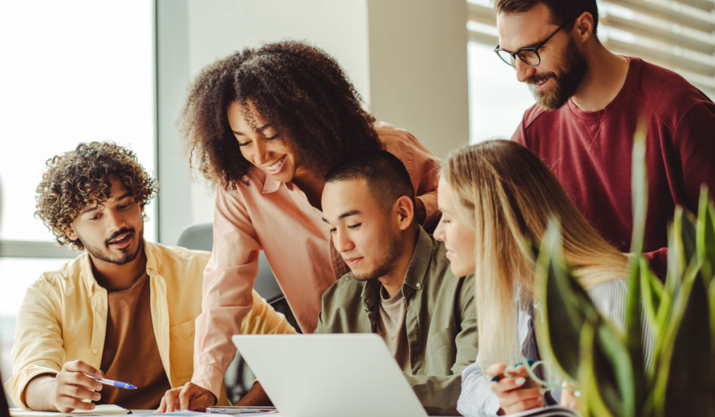 Estudantes universitários trabalhando em uma empresa júnior e colaborando em projetos reais.