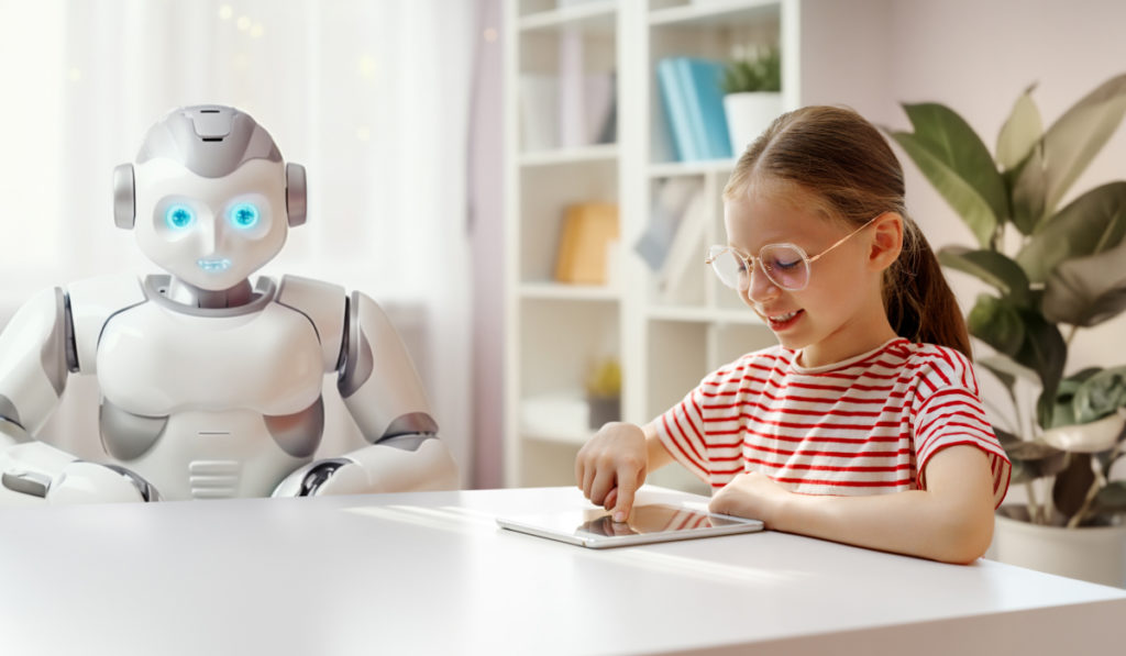 Uma menina de aproximadamente 7 anos estudando através de um tablet, representando como a tecnologia nos estudos.