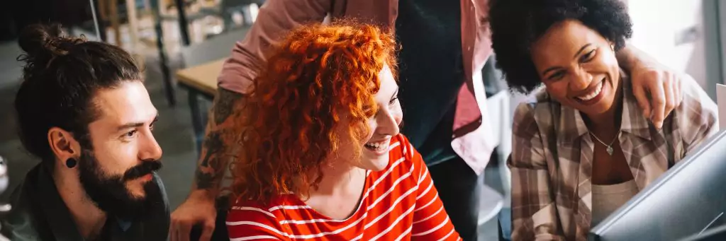 time reunido em torno de computador