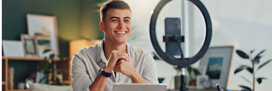 homem sentado em frente a computador e a ring light