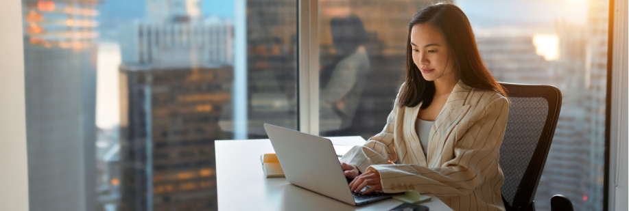 Advogada trabalhando no computador. Ao fundo prédios altos. tecnologia no direito.