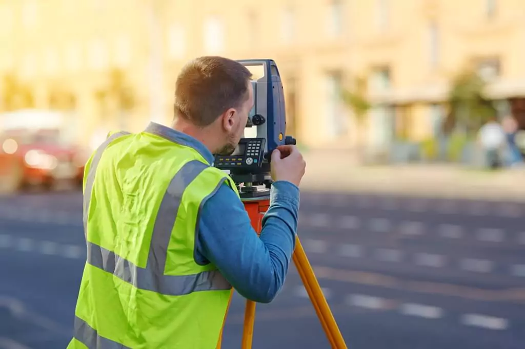 homem com teodolito fazendo medição