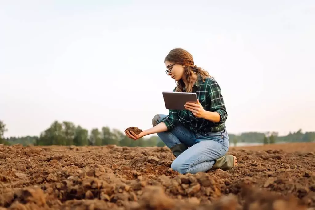moça analisando terra em fazenda