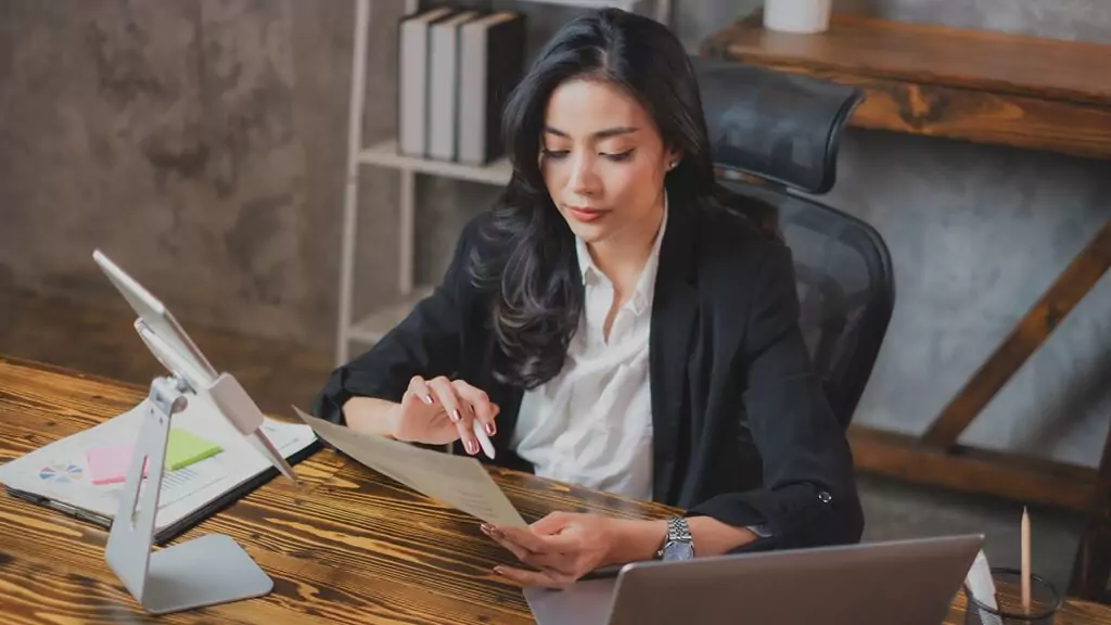 mulher analisando dados em papel
