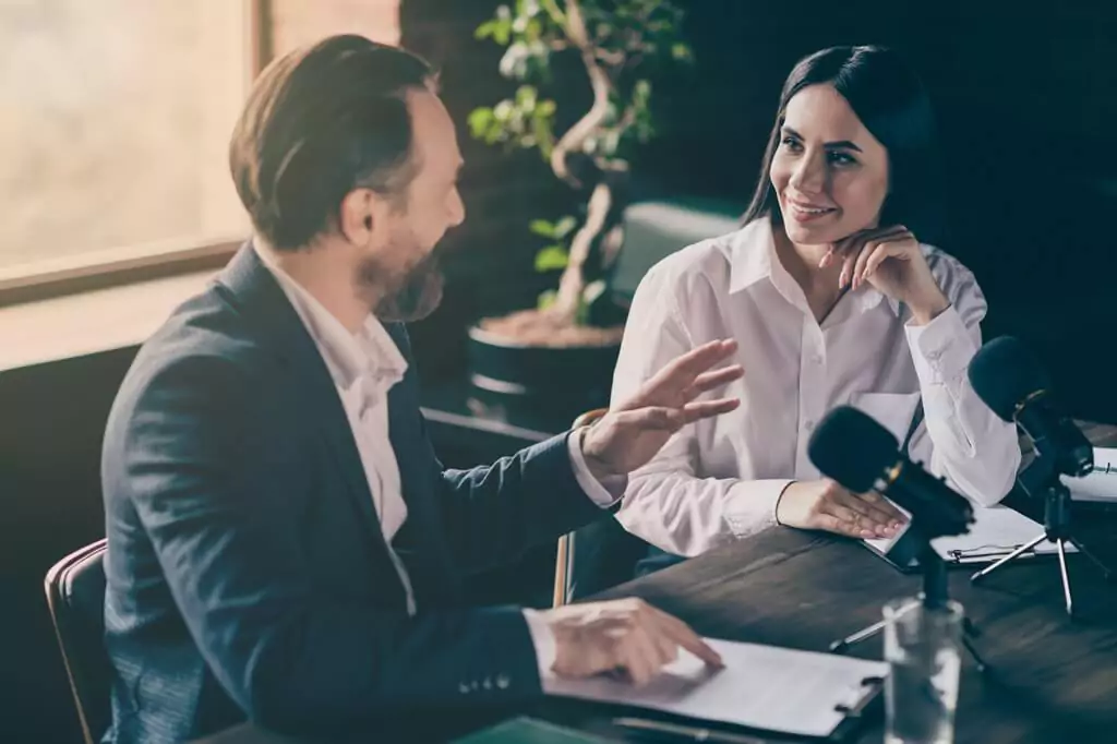 homem e mulher em entrevista de podcast