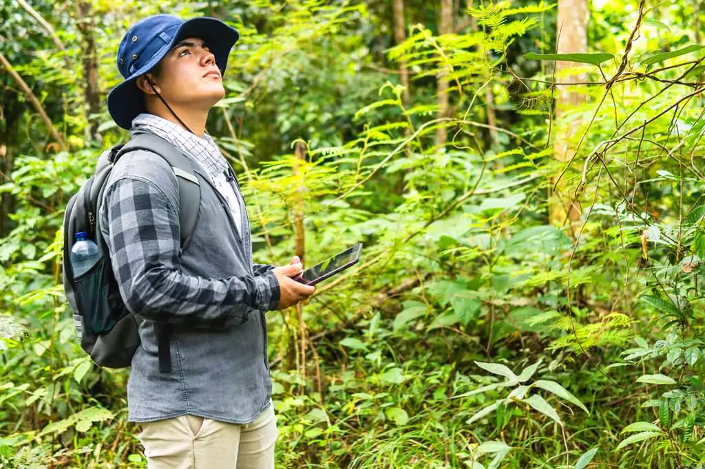 homem com tablet em floresta