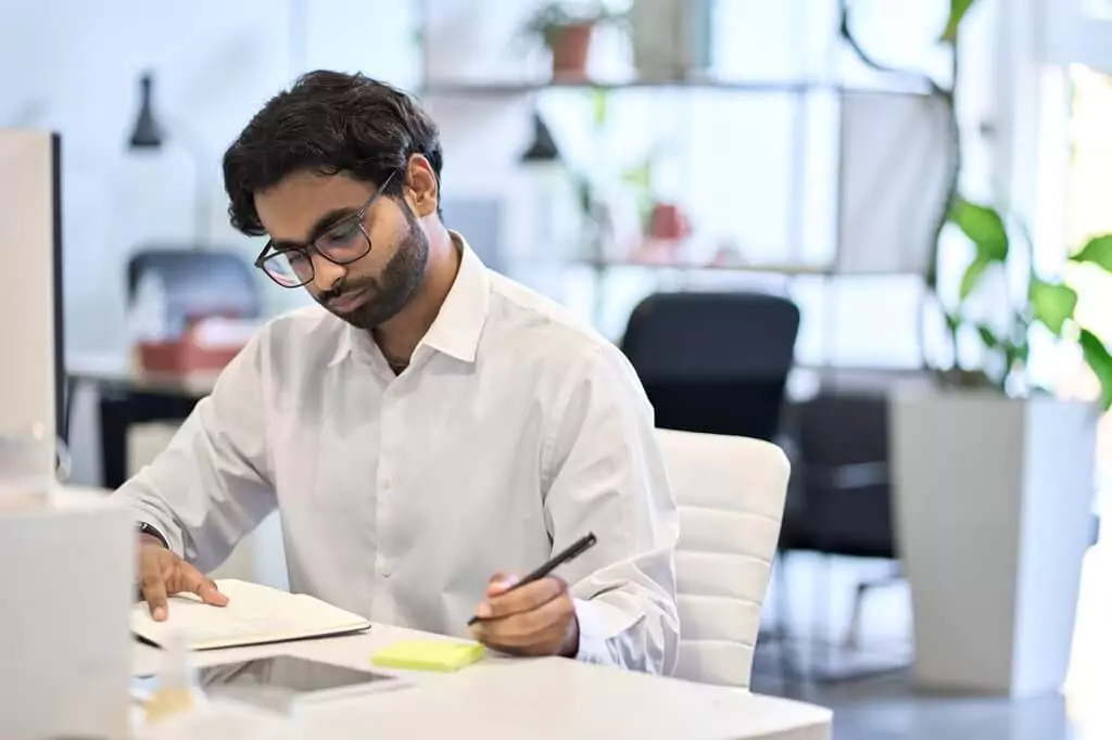 rapaz escrevendo e lendo em escritório