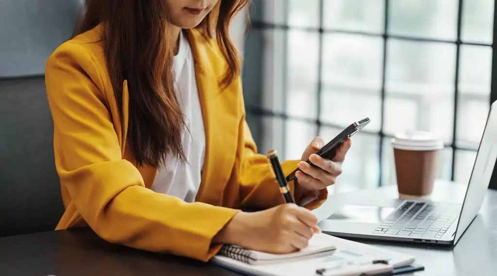 moça em escritório anotando algo em caderno