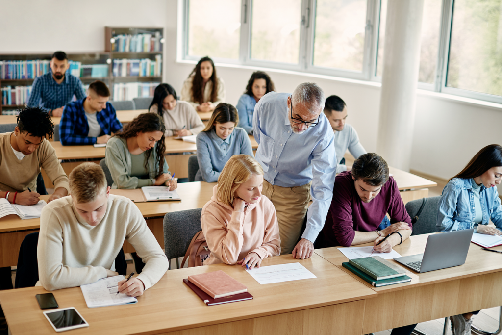 Professor orienta aluna em sala de aula de faculdade. O curso de história combina com você.