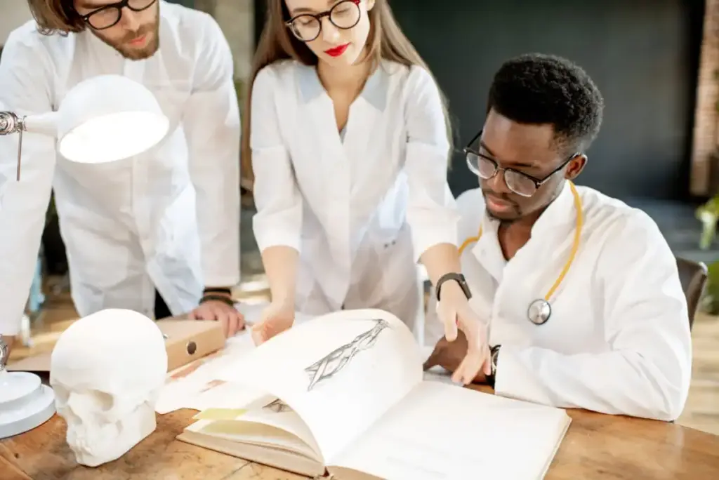 Estudantes de medicina adiquirindo conhecimento em livro sobre anatomia