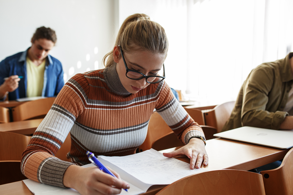Pessoas fazendo prova em sala de aula. Bolsa de estudo para o curso de Letras português e inglês