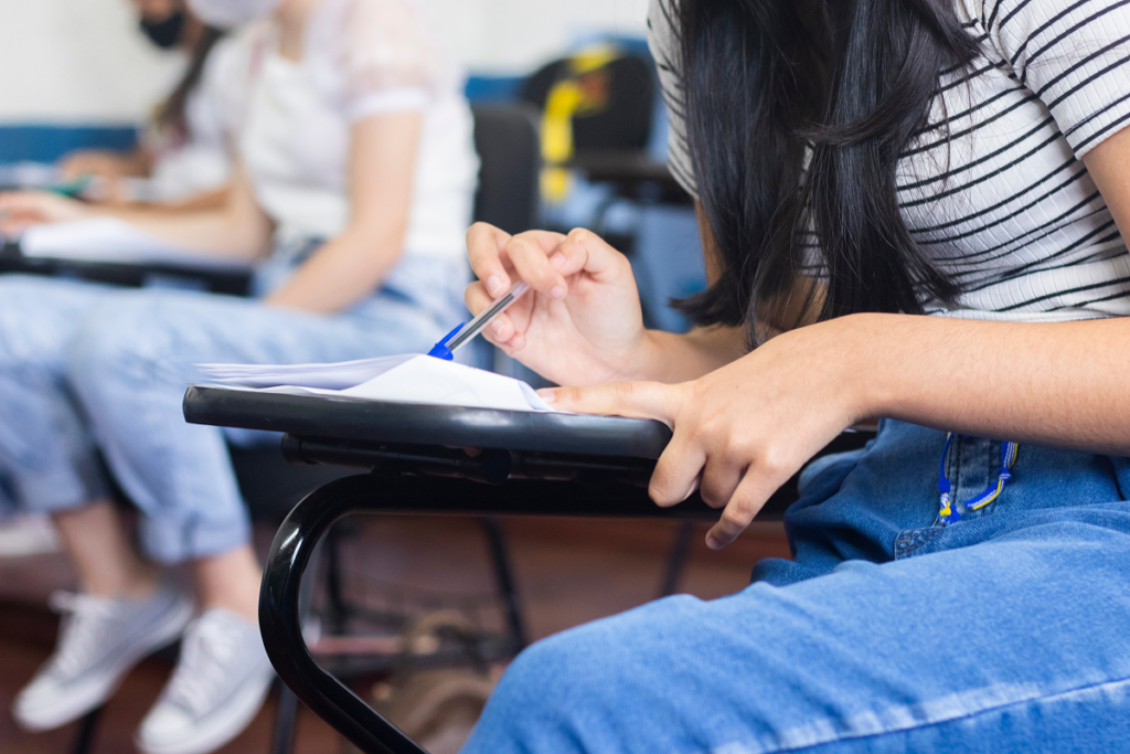 Jovem fazendo prova em sala de aula. Como entrar na faculdade de História