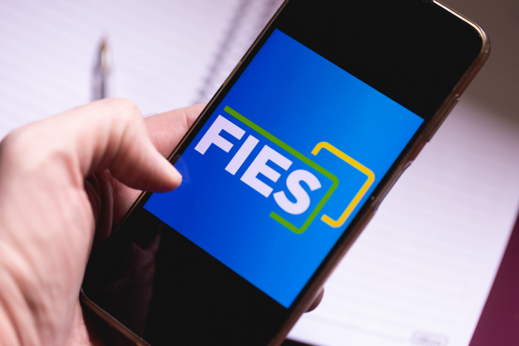 Celular mostra aplicativo do FIES. Como entrar na faculdade de História.