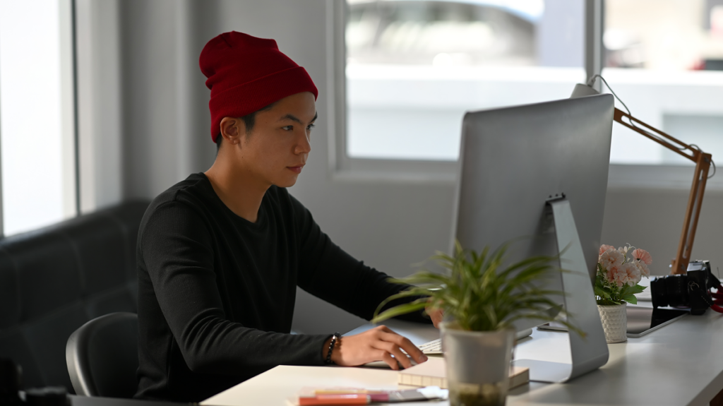 Homem trabalhando no computador. Mercado de trabalho para profissionais de Letras Português e Inglês.