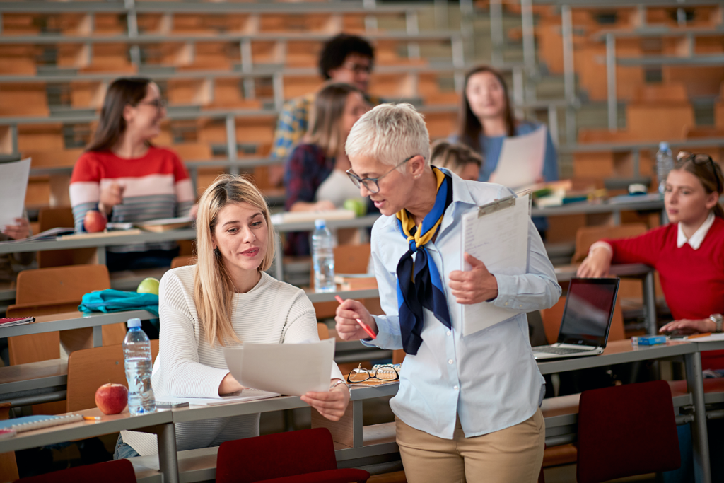 Professora ajudando aluna de universidade. O que faz um profissional de Letras Português e Inglês.