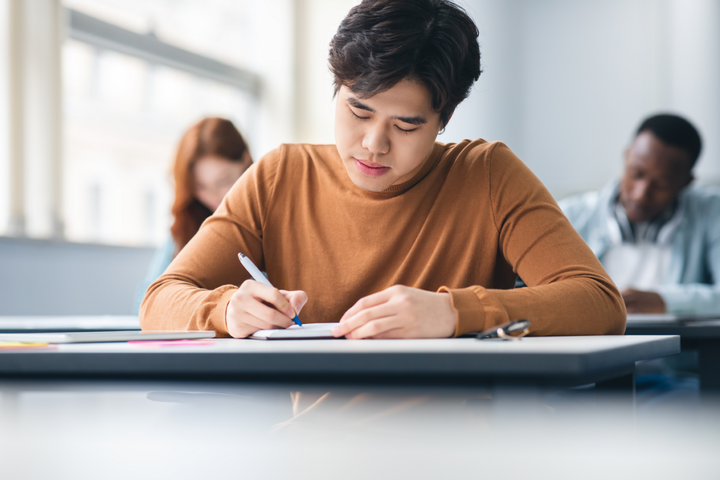 Homem estudando em sala de aula. Quais são as pós graduação em letras.