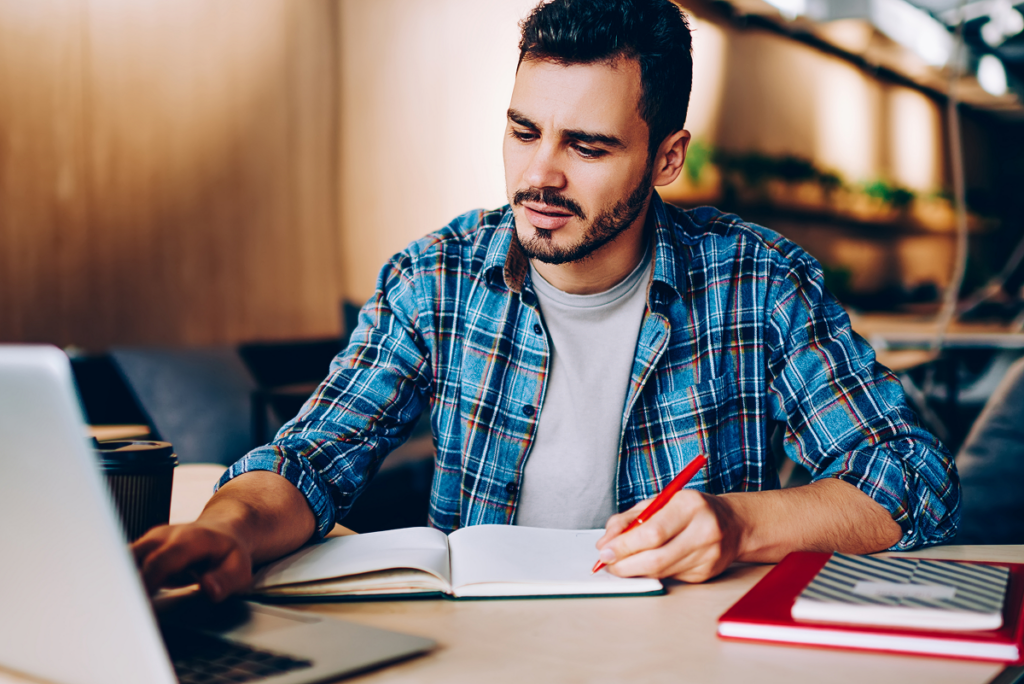 Homem estudando no computador. Curso de Fonoaudiologia presencial ou ead.