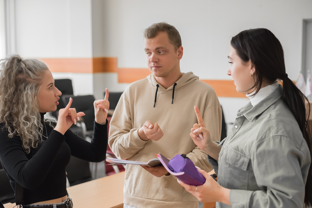 Pessoas falando em libras em sala de aula. Grade curricular do Curso de Fonoaudiologia.