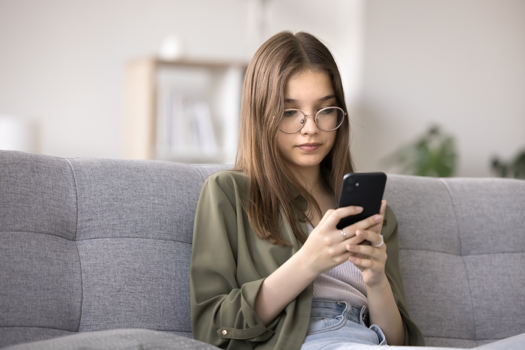 Jovem menina checando informações no celular.